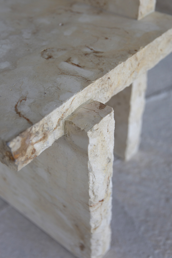 Close view of the seat slab resting on a leg, iron veining in the limestone