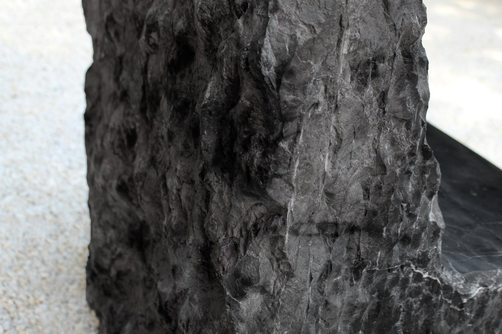 Close view of the split black stone surface beside the smooth seat