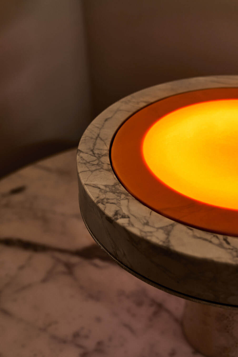 Close view of the disc glowing amber inside the marble ring
