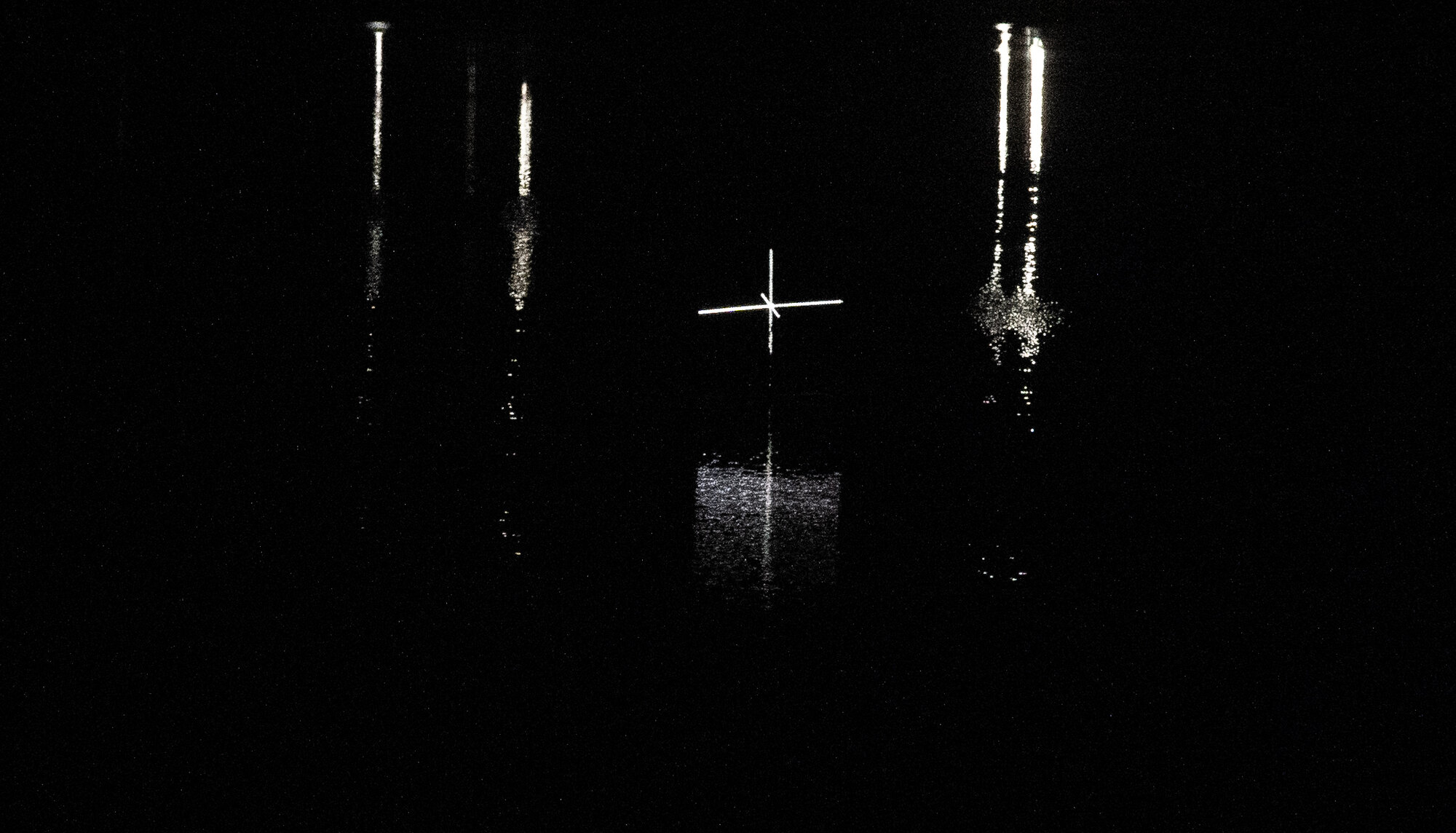 Several light forms on dark water with long reflections