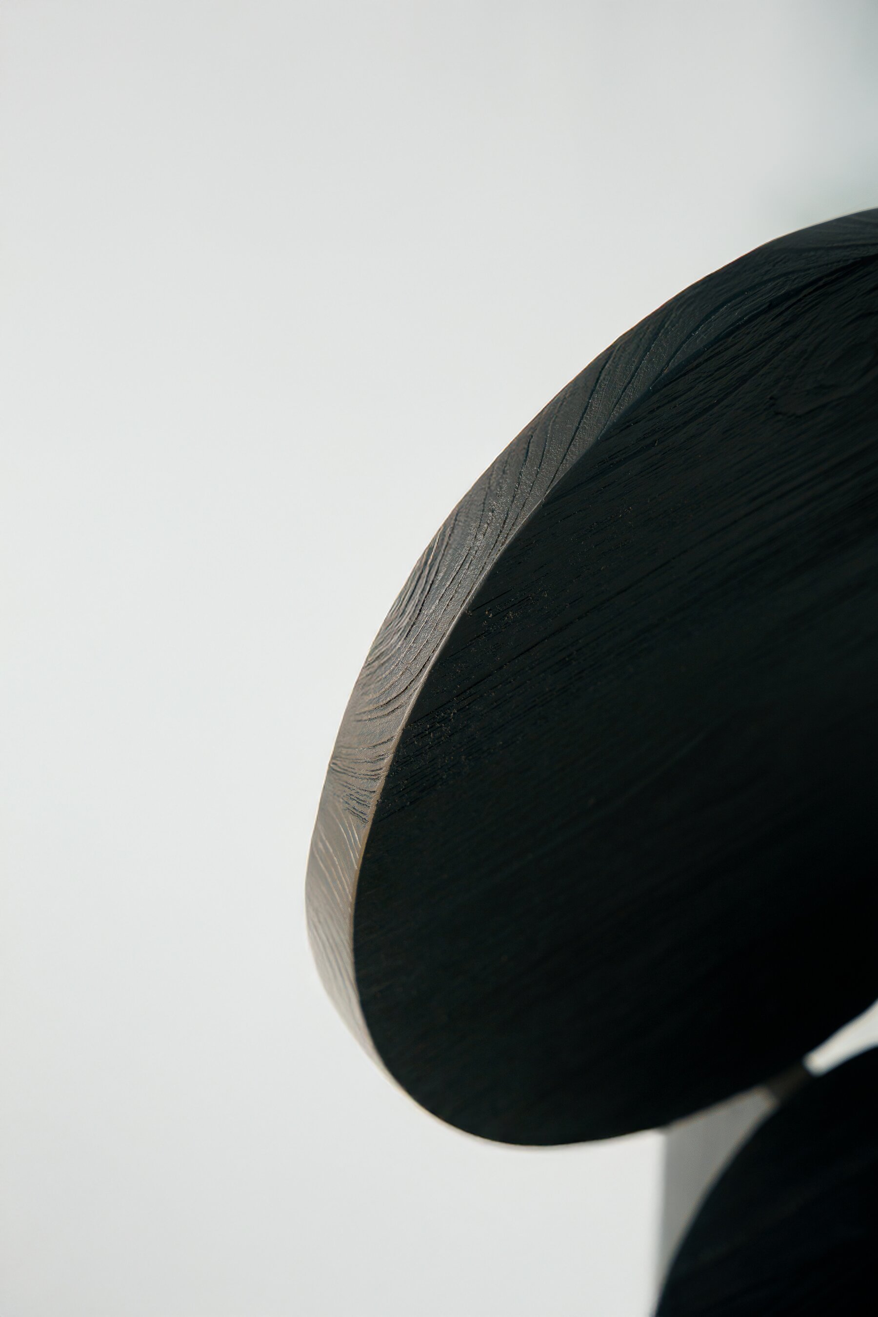 Edge of the round back, teak grain under the black finish